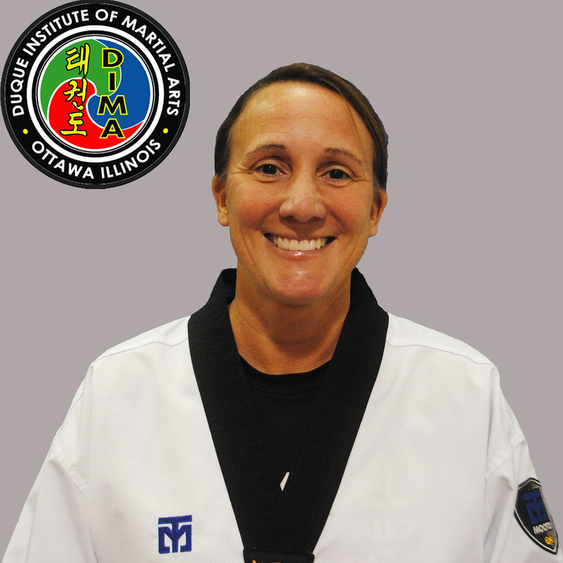 Woman in taekwondo uniform with dark hair pulled back in a ponytail