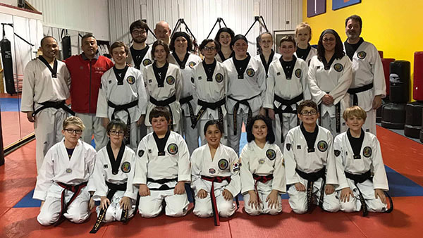 Visiting master poses with master and a large group of black belt students.