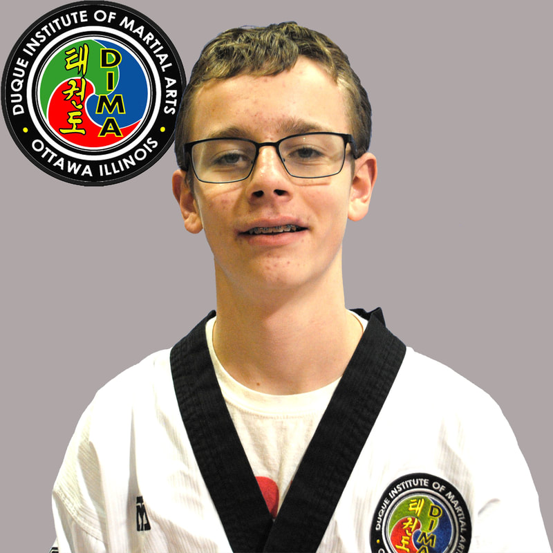 Young boy in taekwondo uniform with short brown hair and glasses