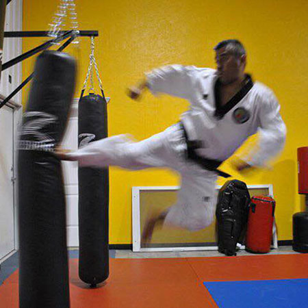 Martial arts master performs flying side kick.