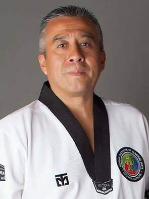Man in taekwondo uniform with short grey hair