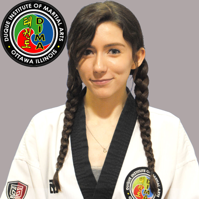 Woman in taekwondo uniform with dark hair in braided pigtails